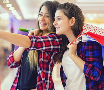 two young women with shopping bags at a mall