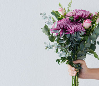 hand holding purple flowers