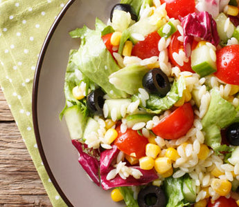 greek orzo salad in white bowl