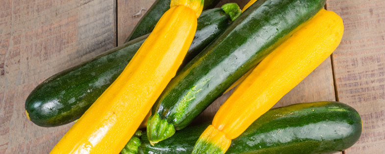 yellow squash and zuchinni stacked on a wooden table