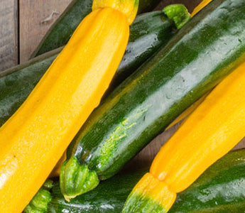 yellow squash and zuchinni stacked on a wooden table