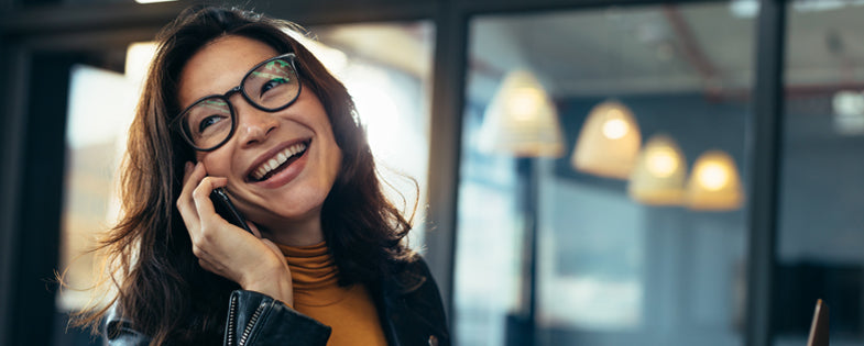 Smiling business woman in casuals talking on phone