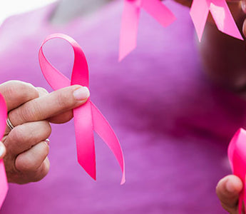 Group of women holding pink ribbons