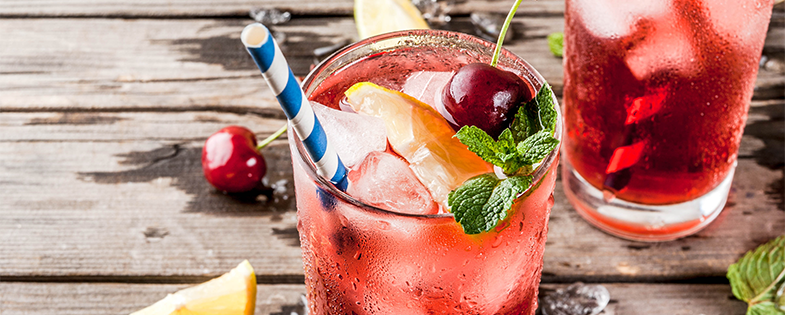 Cherry Lemonade with straw on wooden table