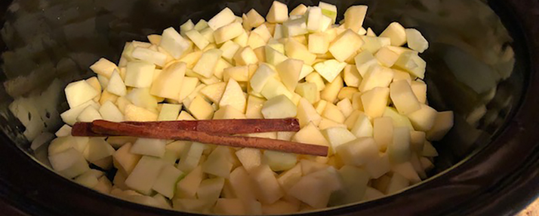 chopped apples and cinnamon sticks in crock pot