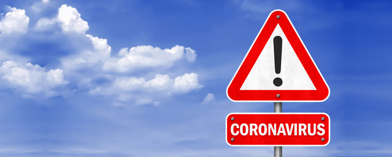 Warning street sign with the word coronavirus underneath, showing a blue sky in the background